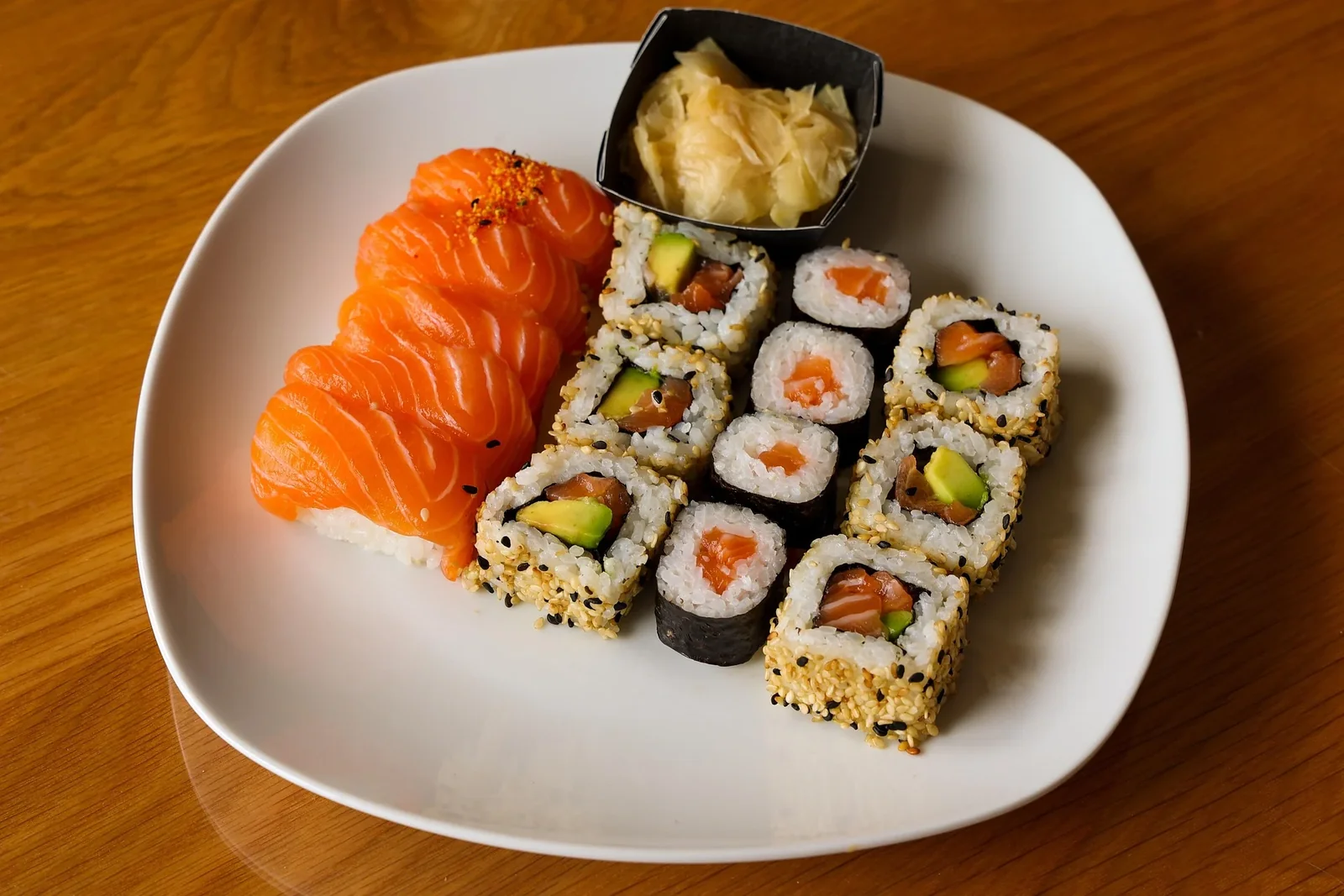 Salmon sashimi and sushi rolls served with pickled ginger