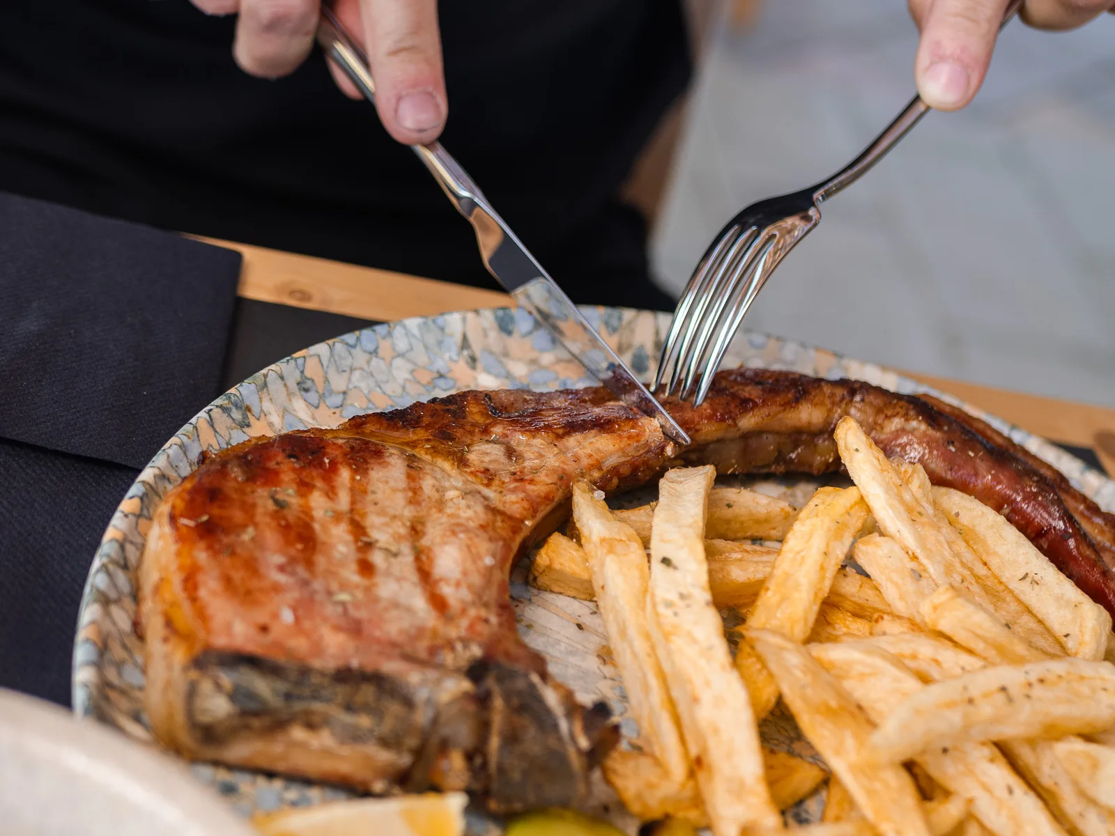 A grilled pork chop with fries at Eterna