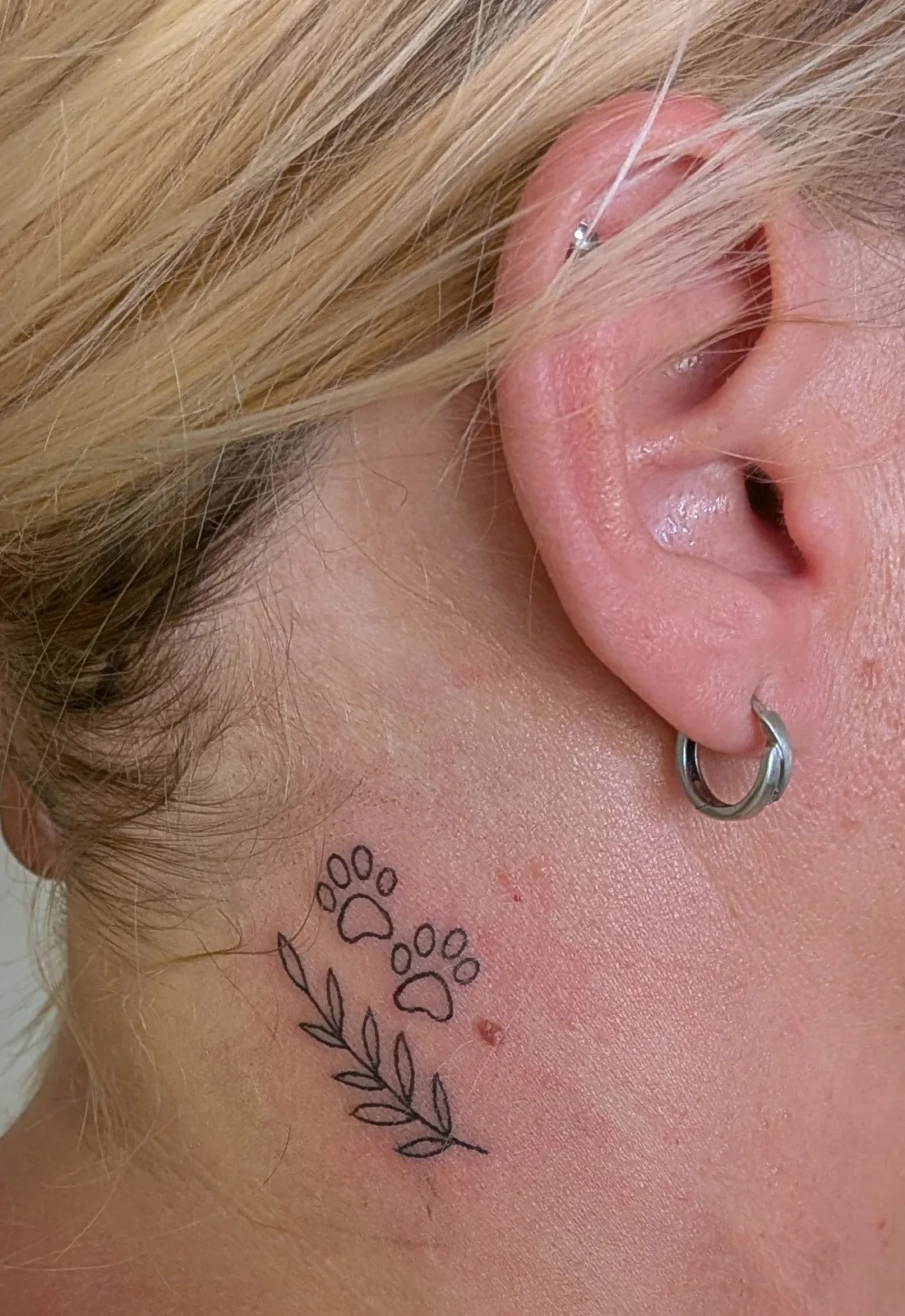 Ear jewellery and a fine neck tattoo